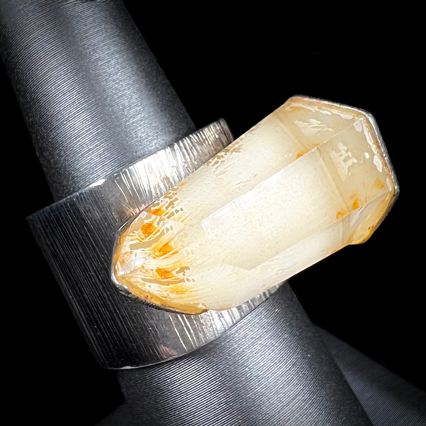 A sterling silver ring set with a naturally terminated yellow citrine quartz crystal.