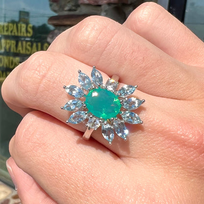 A faceted oval cut blue Ethiopian fire opal set in a sterling silver ring with marquise cut blue topaz stones.