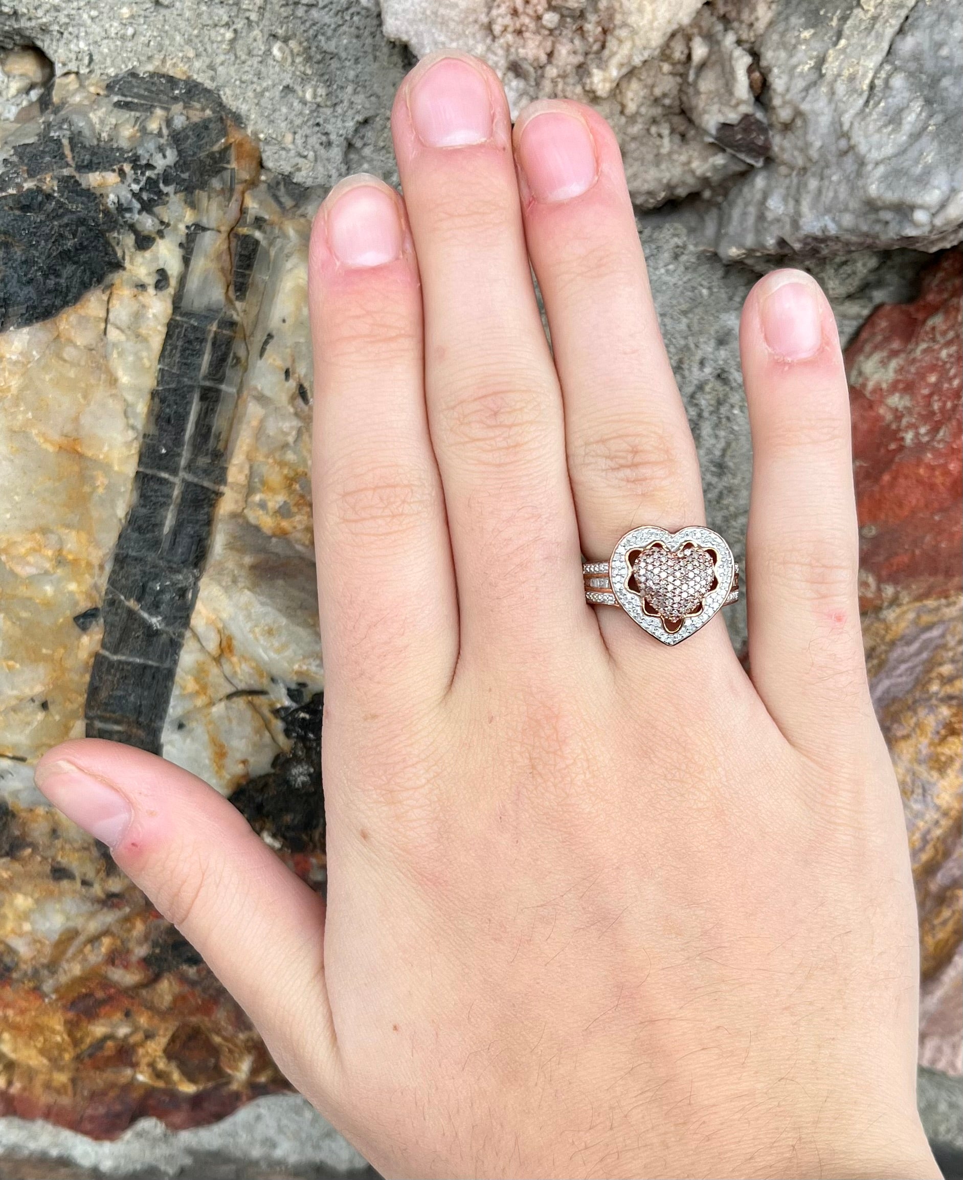 A rose colored metal ring pavé set with round and baguette cut diamonds.