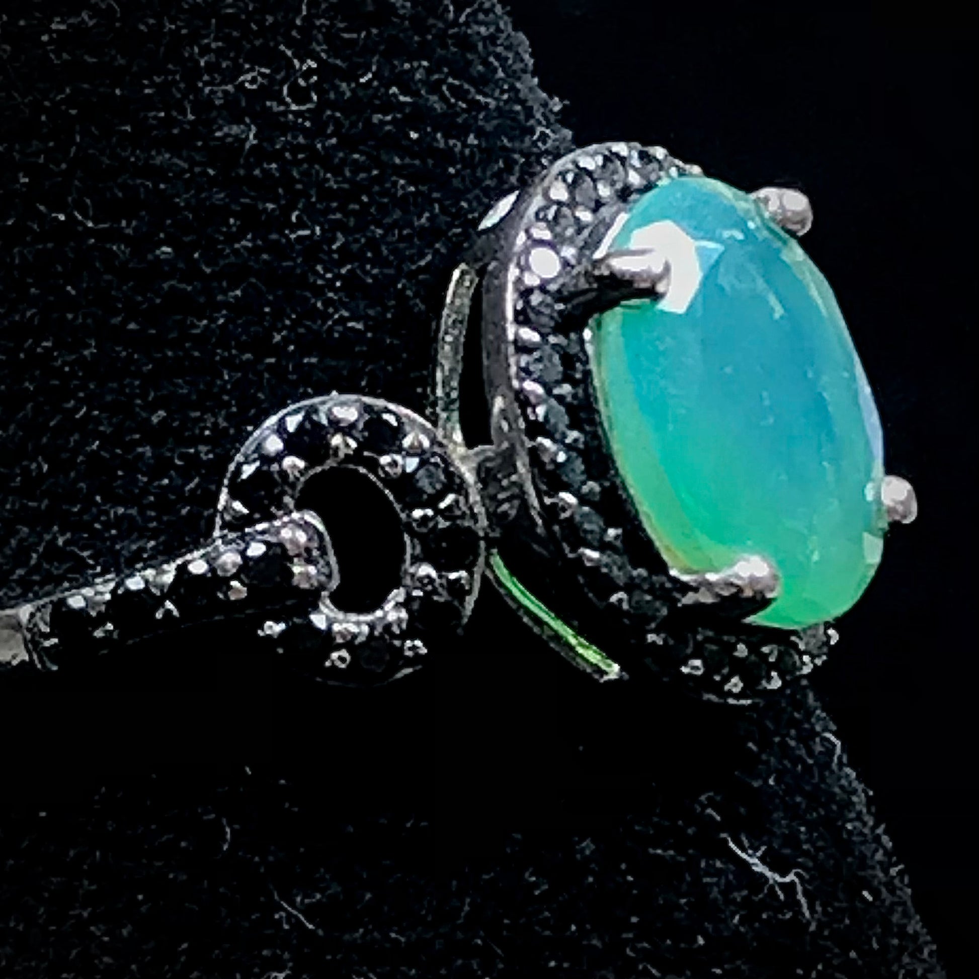 Dyed Ethiopian opal and black spinel prong set into a sterling silver ring.