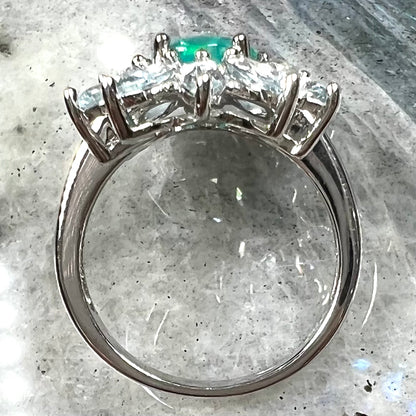 A faceted oval cut blue Ethiopian fire opal set in a sterling silver ring with marquise cut blue topaz stones.