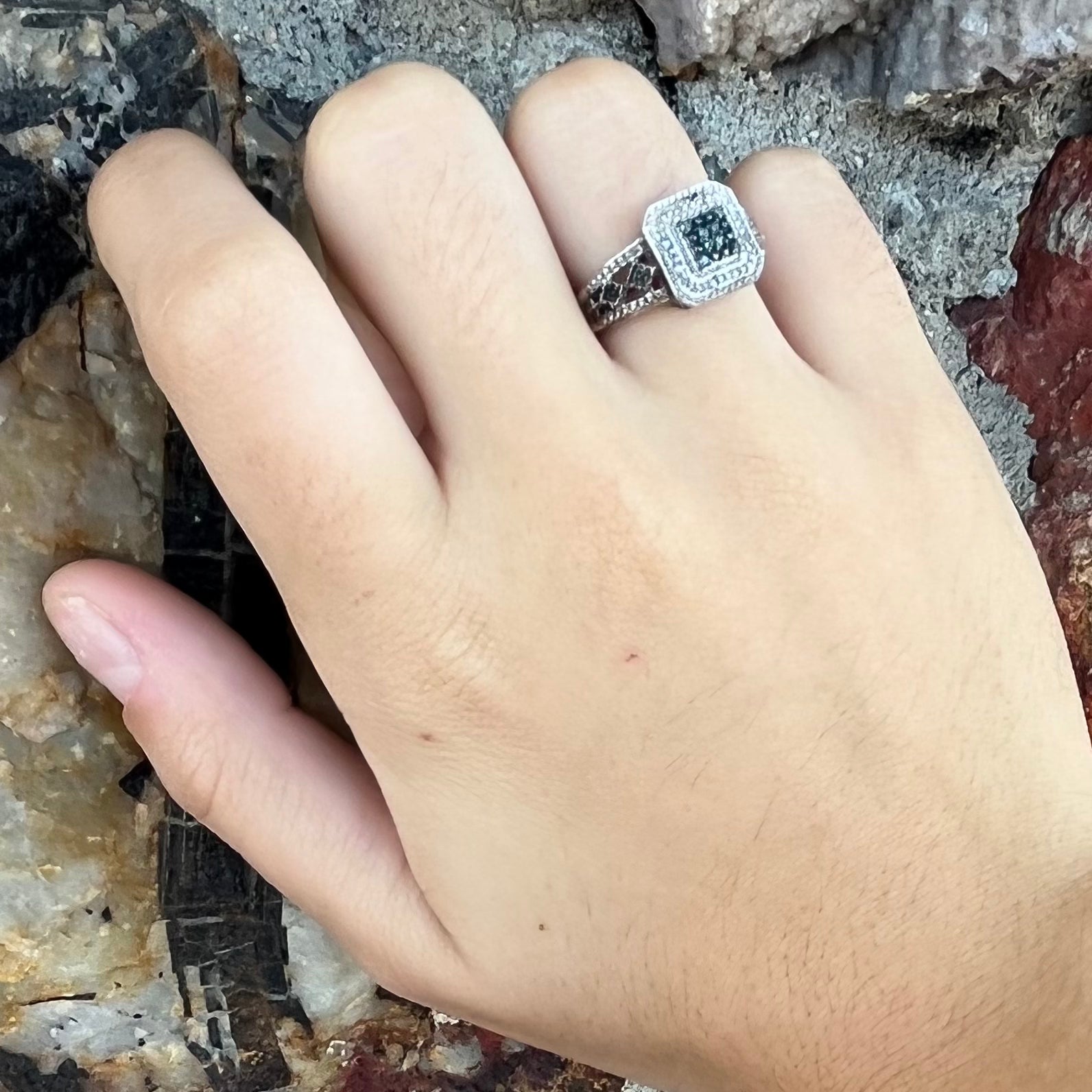 A sterling silver ring set with blue and white diamonds.