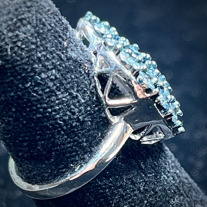 A sterling silver heart ring set with blue diamonds.