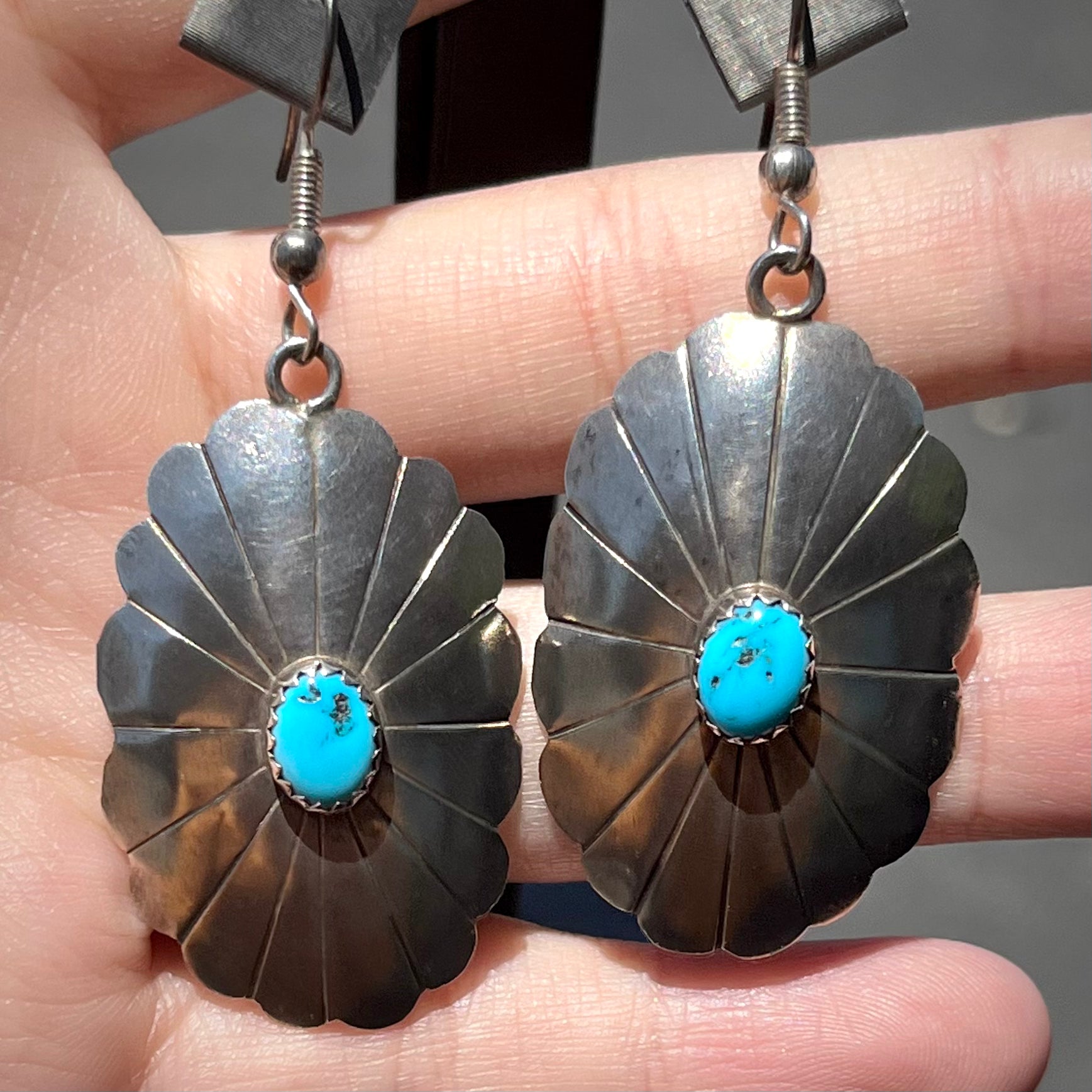 A pair of sterling silver concho turquoise dangle earrings.