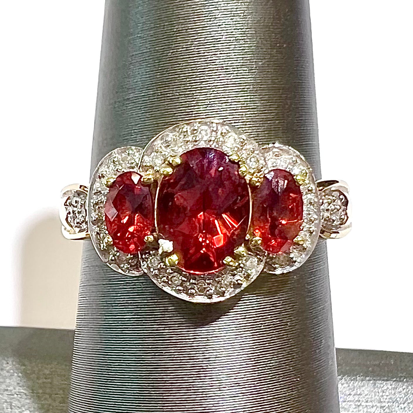 Past, present, future style red andesine feldspar and diamond halo ring cast in 14kt yellow gold.