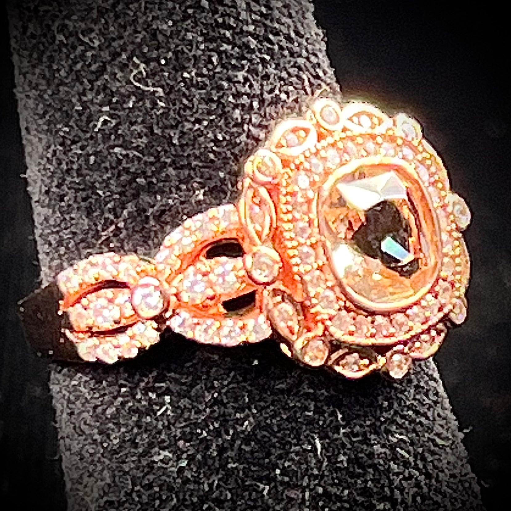 A rose gold plated ring set with a cushion cut morganite stone surrounded by cubic zirconia halos.