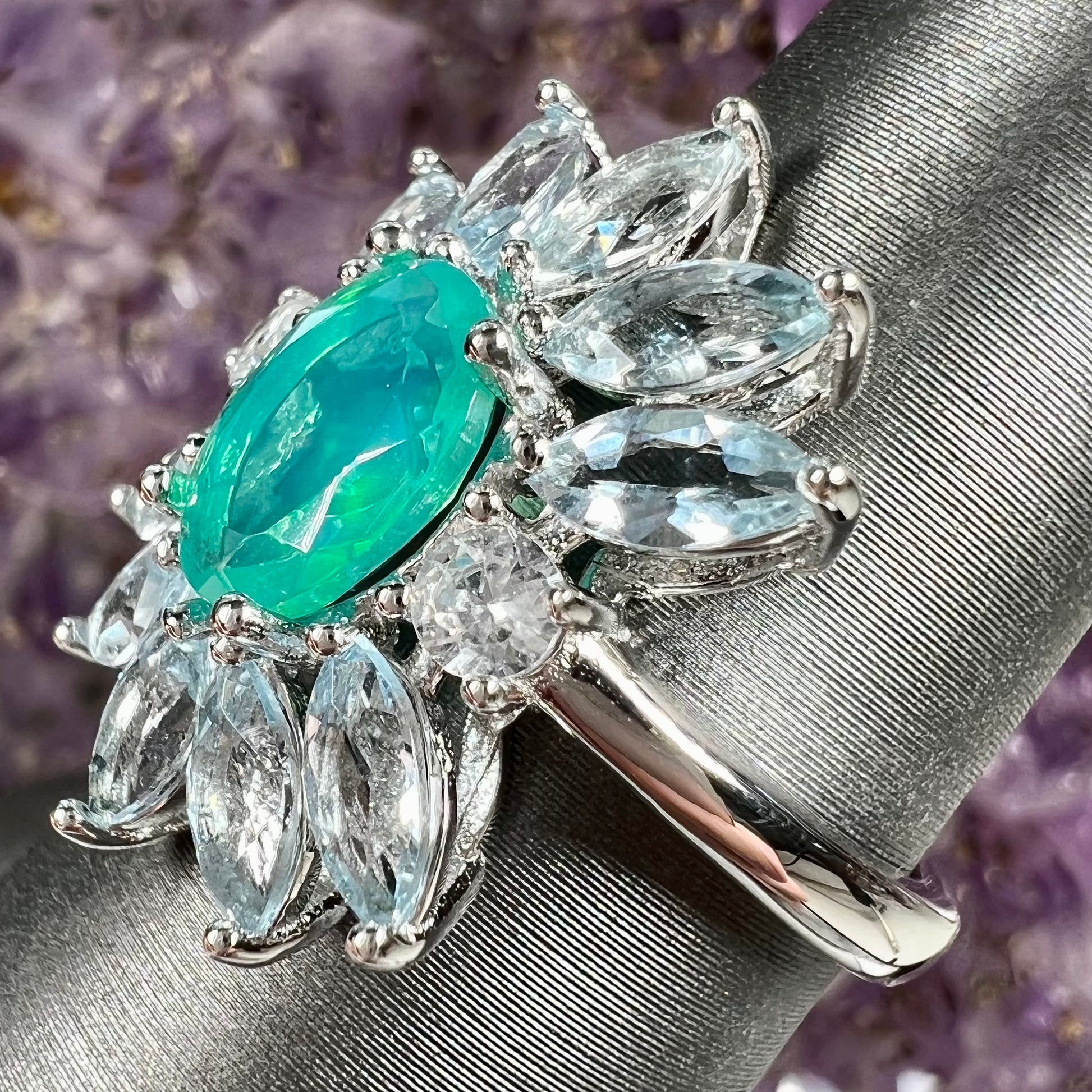 A faceted oval cut blue Ethiopian fire opal set in a sterling silver ring with marquise cut blue topaz stones.