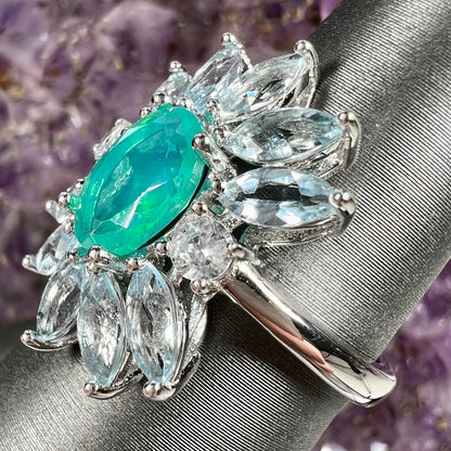 A faceted oval cut blue Ethiopian fire opal set in a sterling silver ring with marquise cut blue topaz stones.