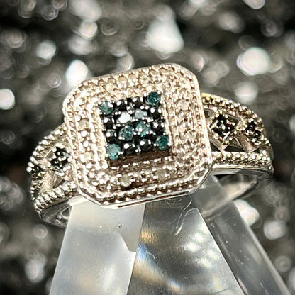 A sterling silver ring set with blue and white diamonds.