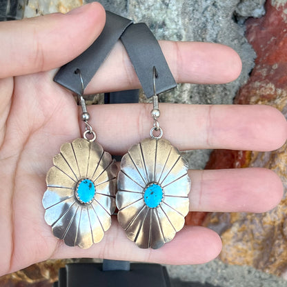 A pair of sterling silver concho turquoise dangle earrings.
