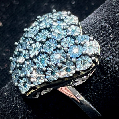 A sterling silver heart ring set with blue diamonds.