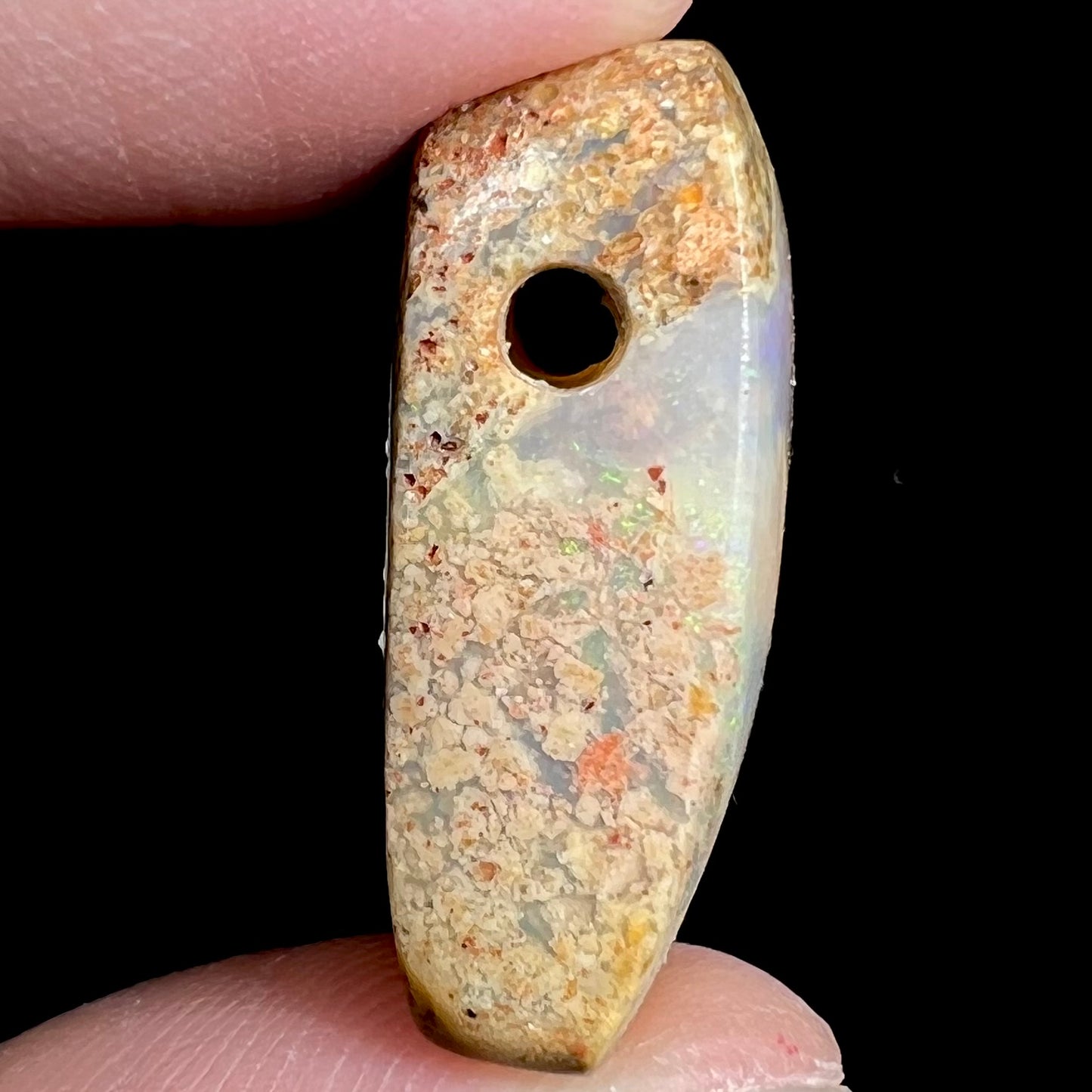 A polished, drilled pipe boulder opal bead.
