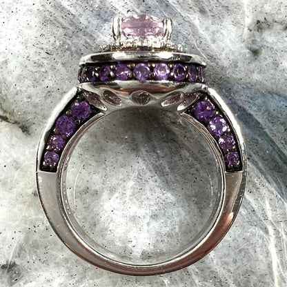 A sterling silver oval cut kunzite ring set with a double halo of round cut CZ and amethysts.