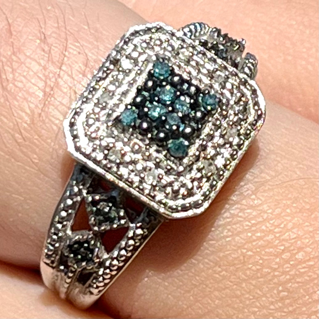 A sterling silver ring set with blue and white diamonds.