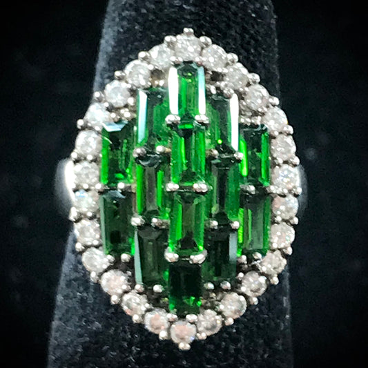 A sterling silver marquise shape ring set with green baguette cut stones.