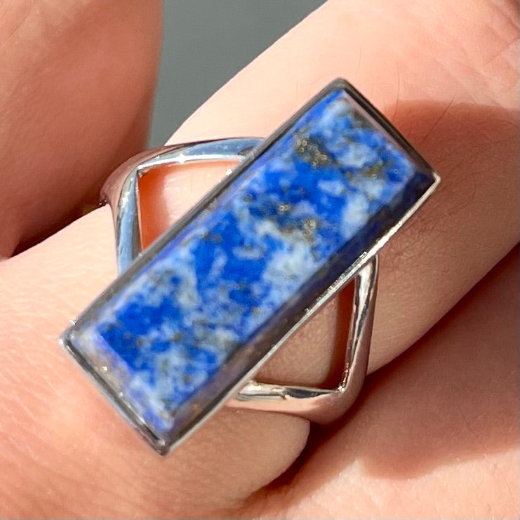 A split shank silver rectangular cabochon cut lapis lazuli ring.