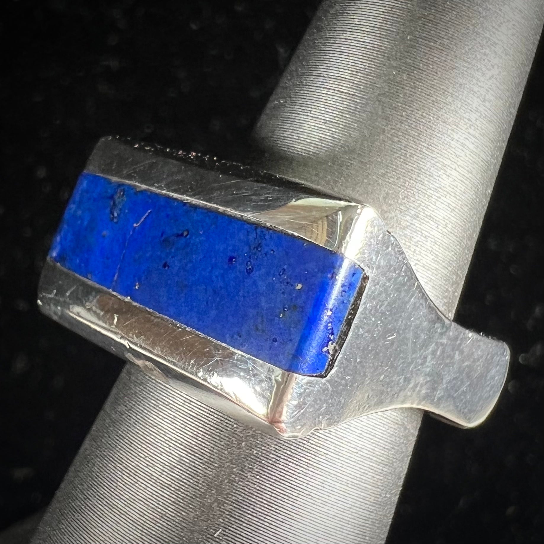 A sterling silver ring inlaid with a piece of lapis lazuli.  A small crack runs through the piece of lapis.