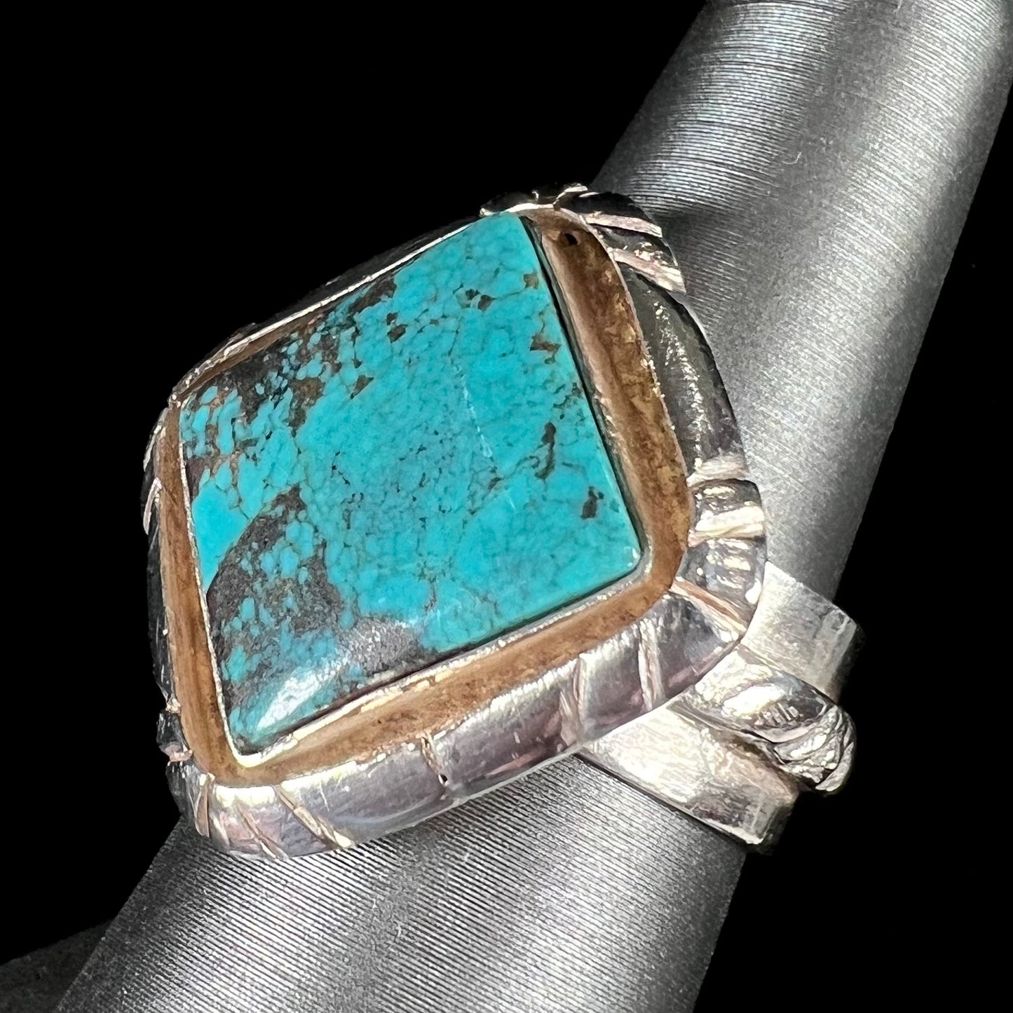 A handmade sterling silver, unisex, likely Navajo ring set with Tibetan turquoise.