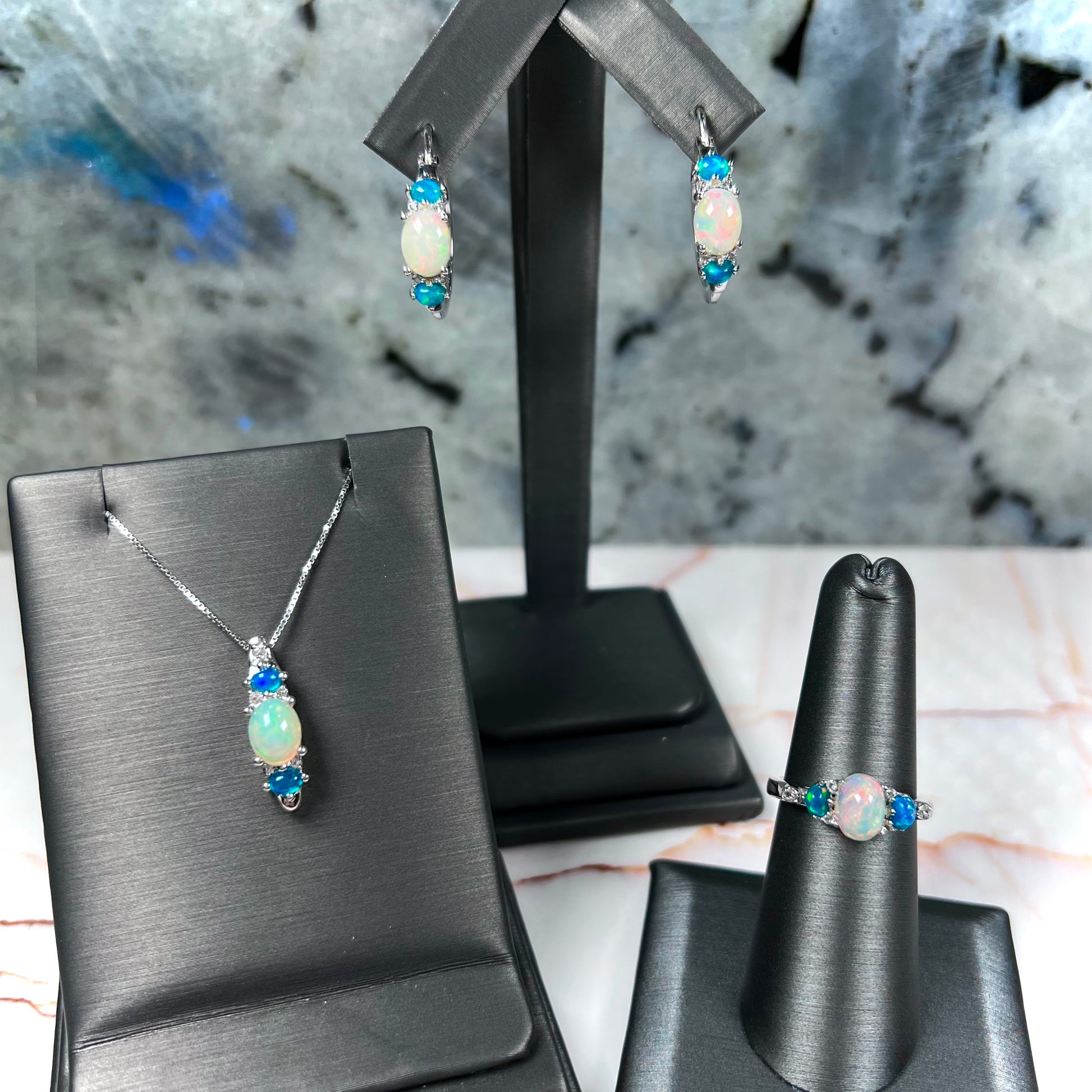 A sterling silver ring, earring, and necklace set made of Ethiopian opals and cubic zirconia.