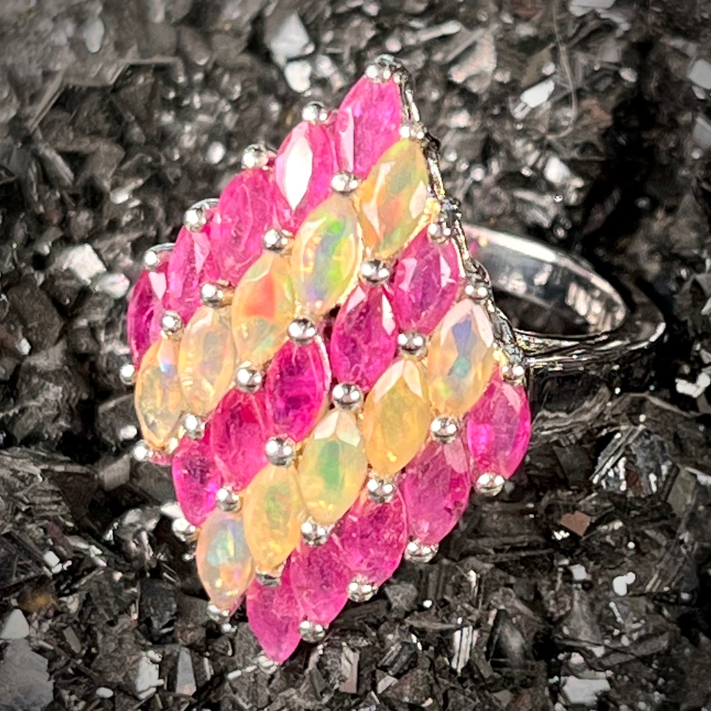 A silver ring set with a cluster of marquise cut rubies and orange Ethiopian fire opals.