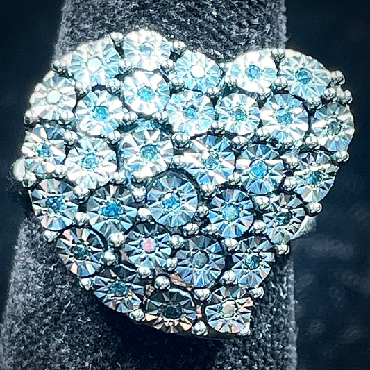 A sterling silver heart ring set with blue diamonds.