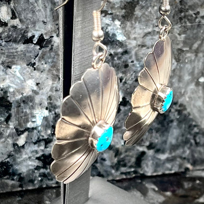 A pair of sterling silver concho turquoise dangle earrings.