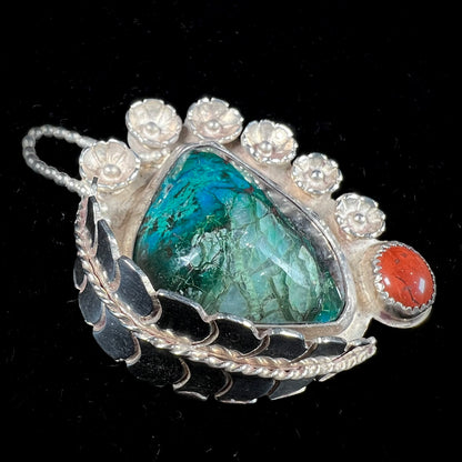 A sterling silver Navajo-style pendant set with chrysocolla and red jasper stones.