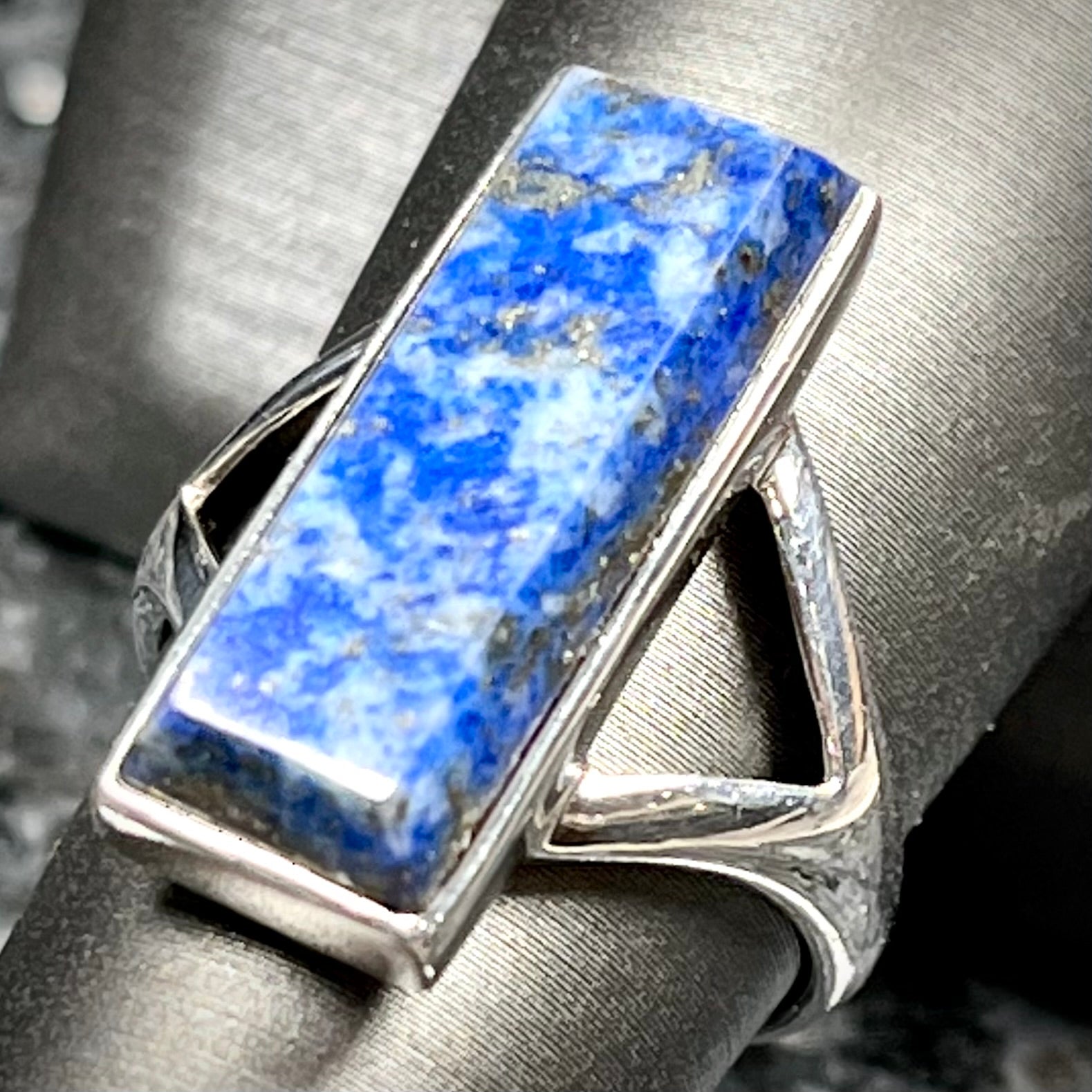 A split shank silver rectangular cabochon cut lapis lazuli ring.