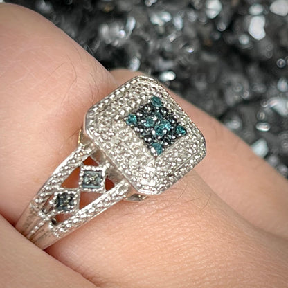 A sterling silver ring set with blue and white diamonds.