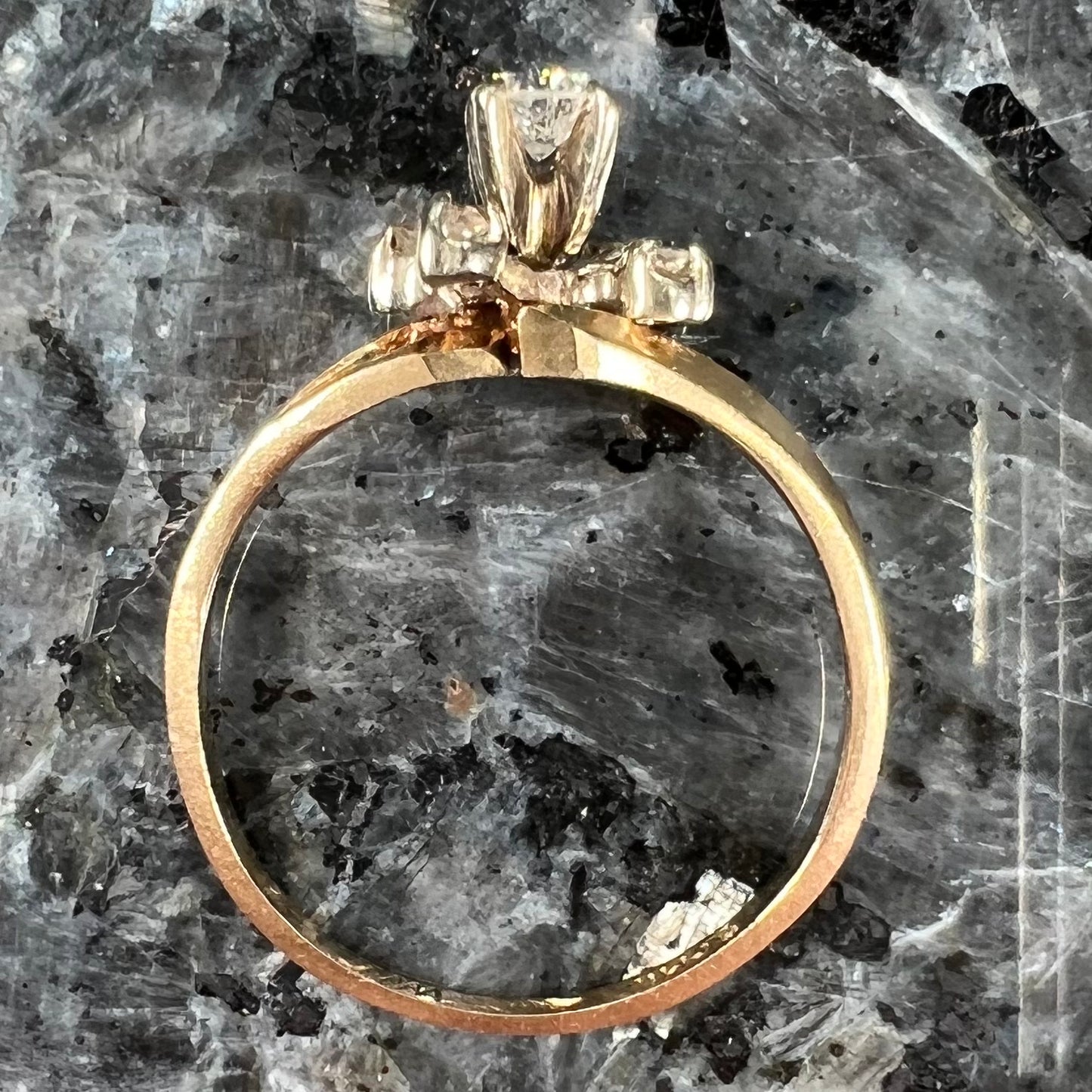 A yellow gold high-set diamond ring with four side diamonds.