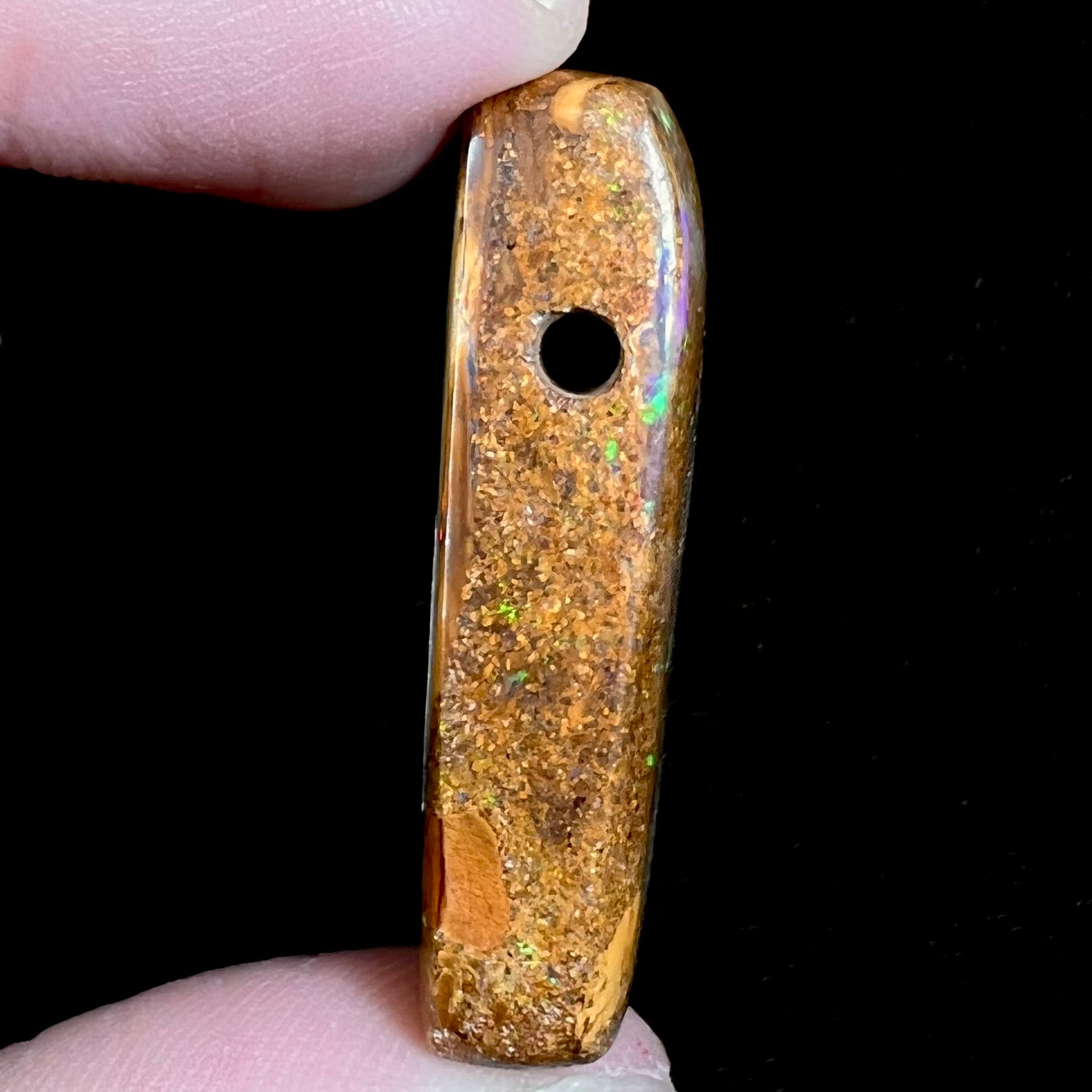 A polished, drilled pipe boulder opal bead.