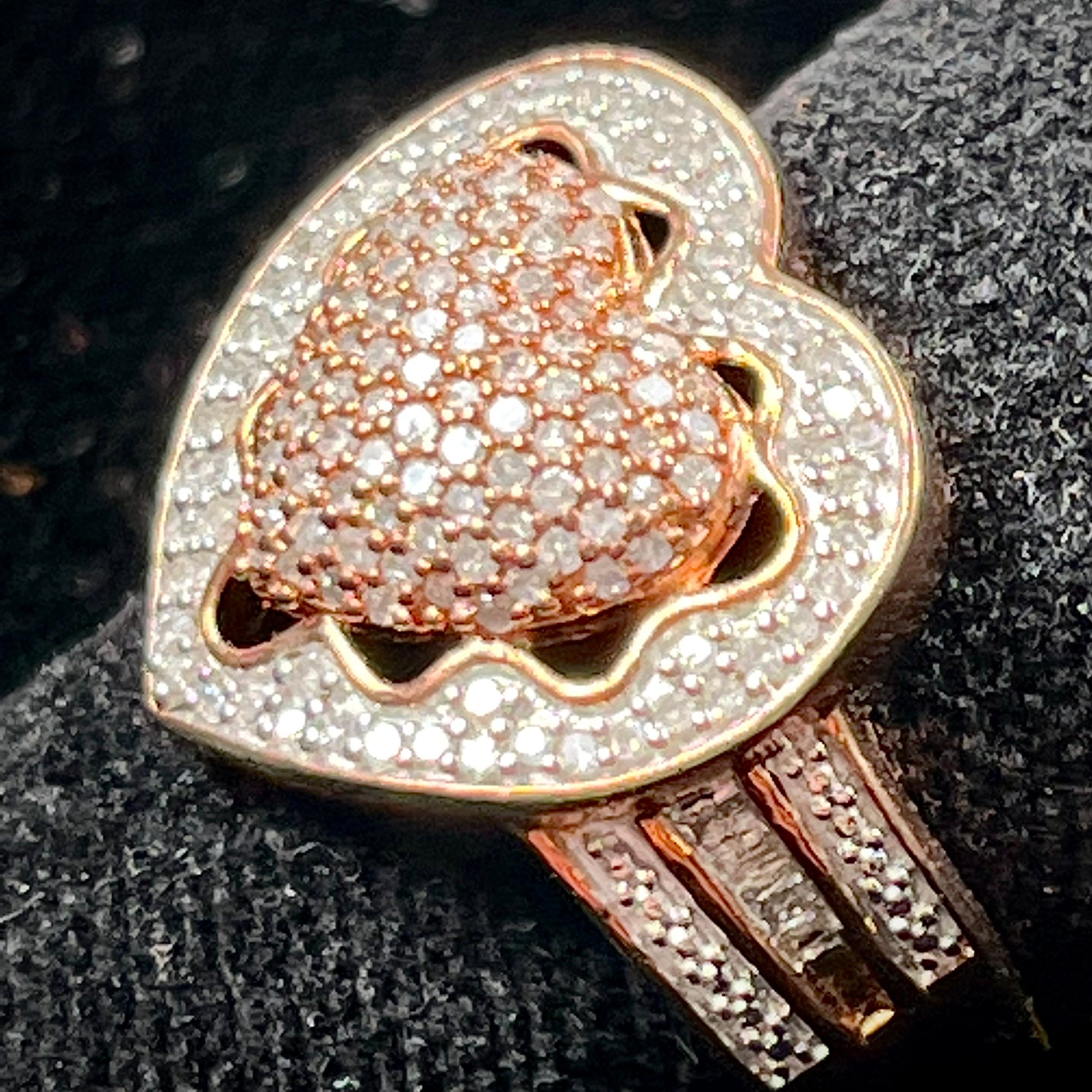 A rose colored metal ring pavé set with round and baguette cut diamonds.