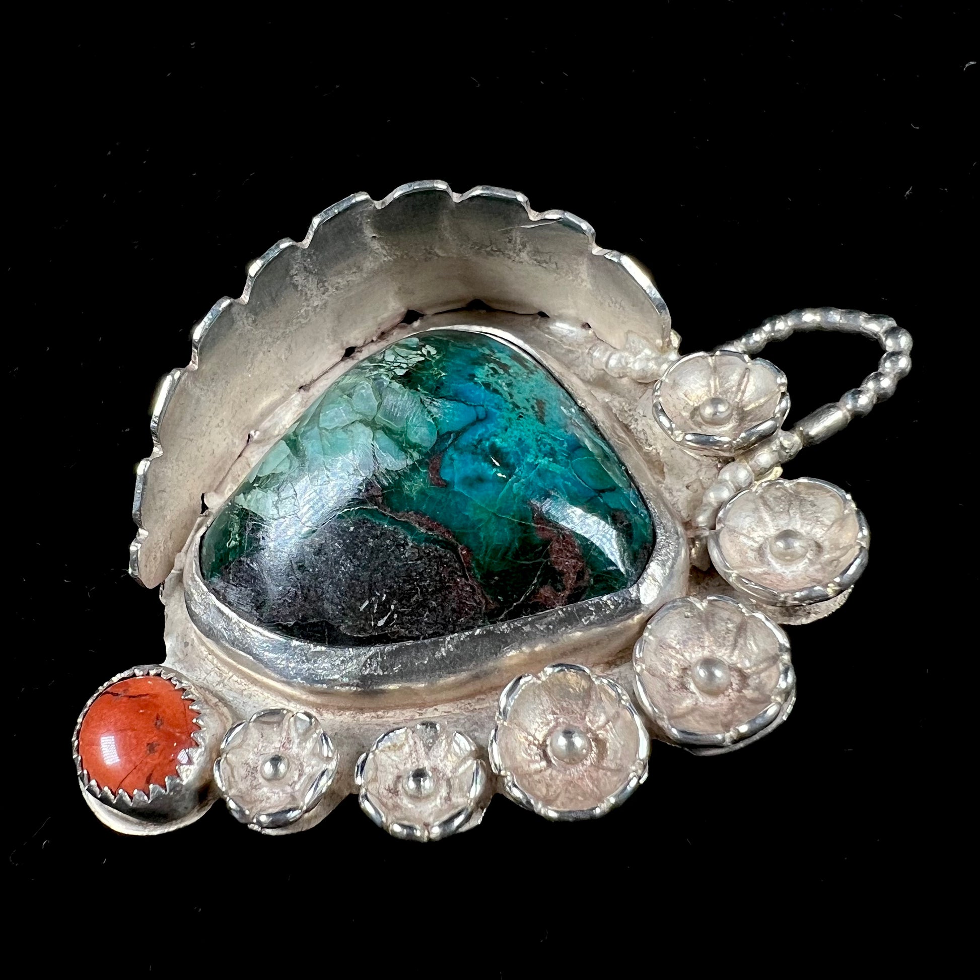 A sterling silver Navajo-style pendant set with chrysocolla and red jasper stones.