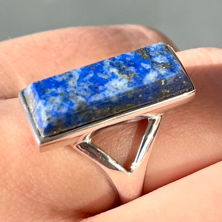 A split shank silver rectangular cabochon cut lapis lazuli ring.