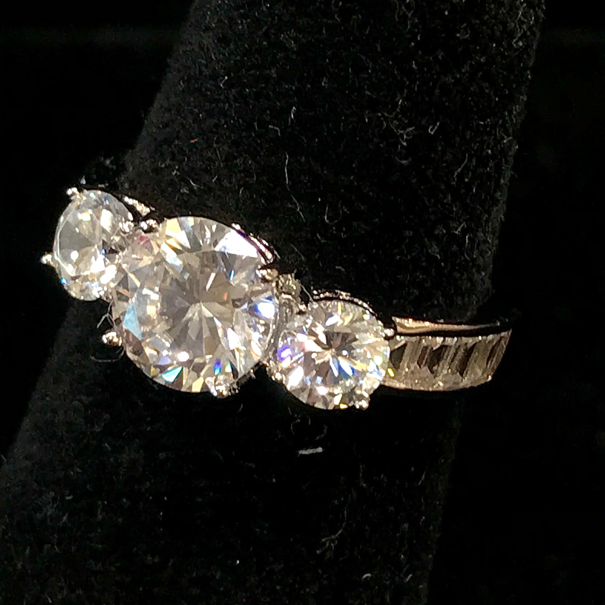 A sterling silver ring set with three round cut cubic zirconia stones.