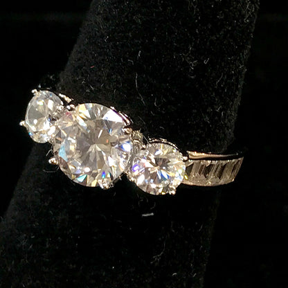 A sterling silver ring set with three round cut cubic zirconia stones.