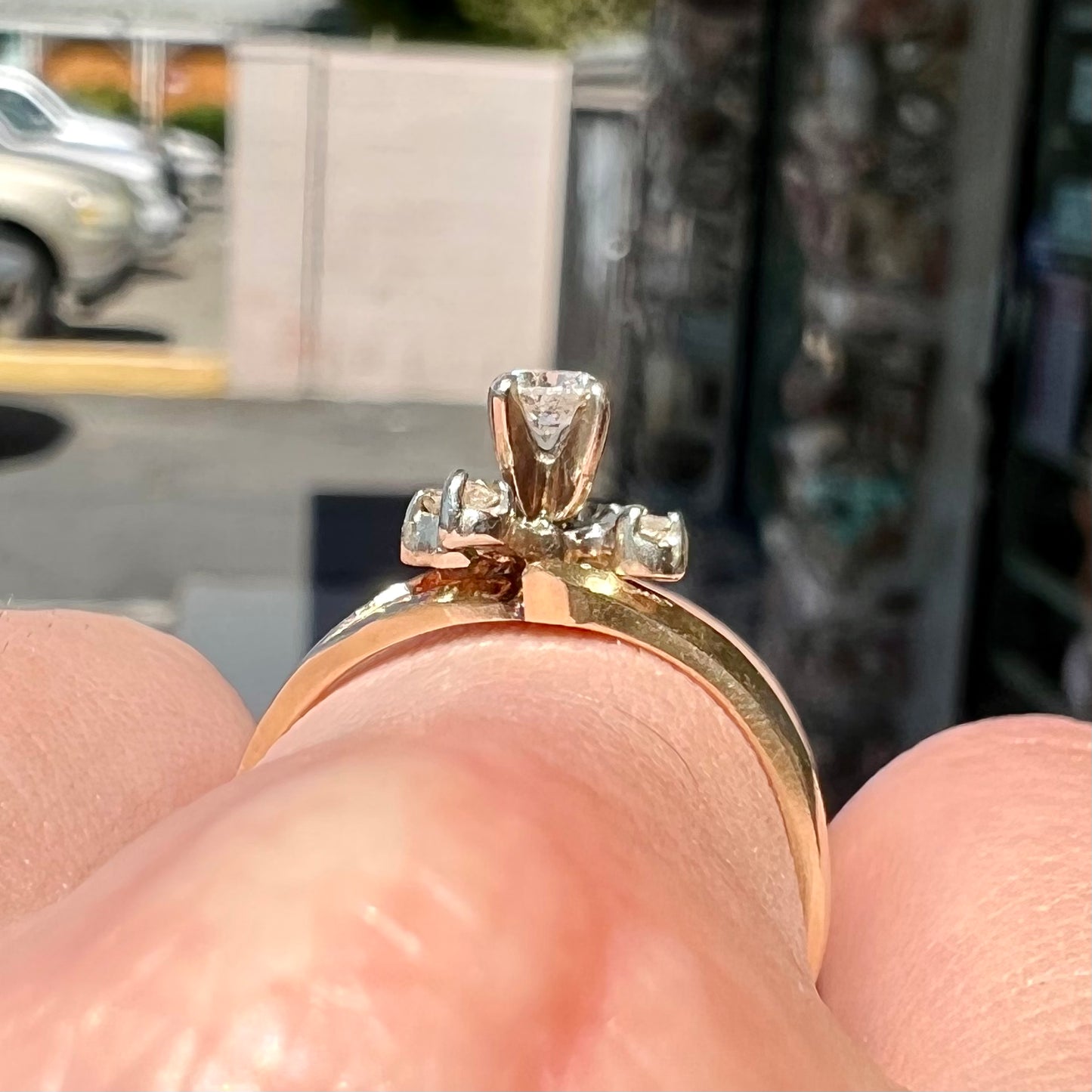 A yellow gold high-set diamond ring with four side diamonds.