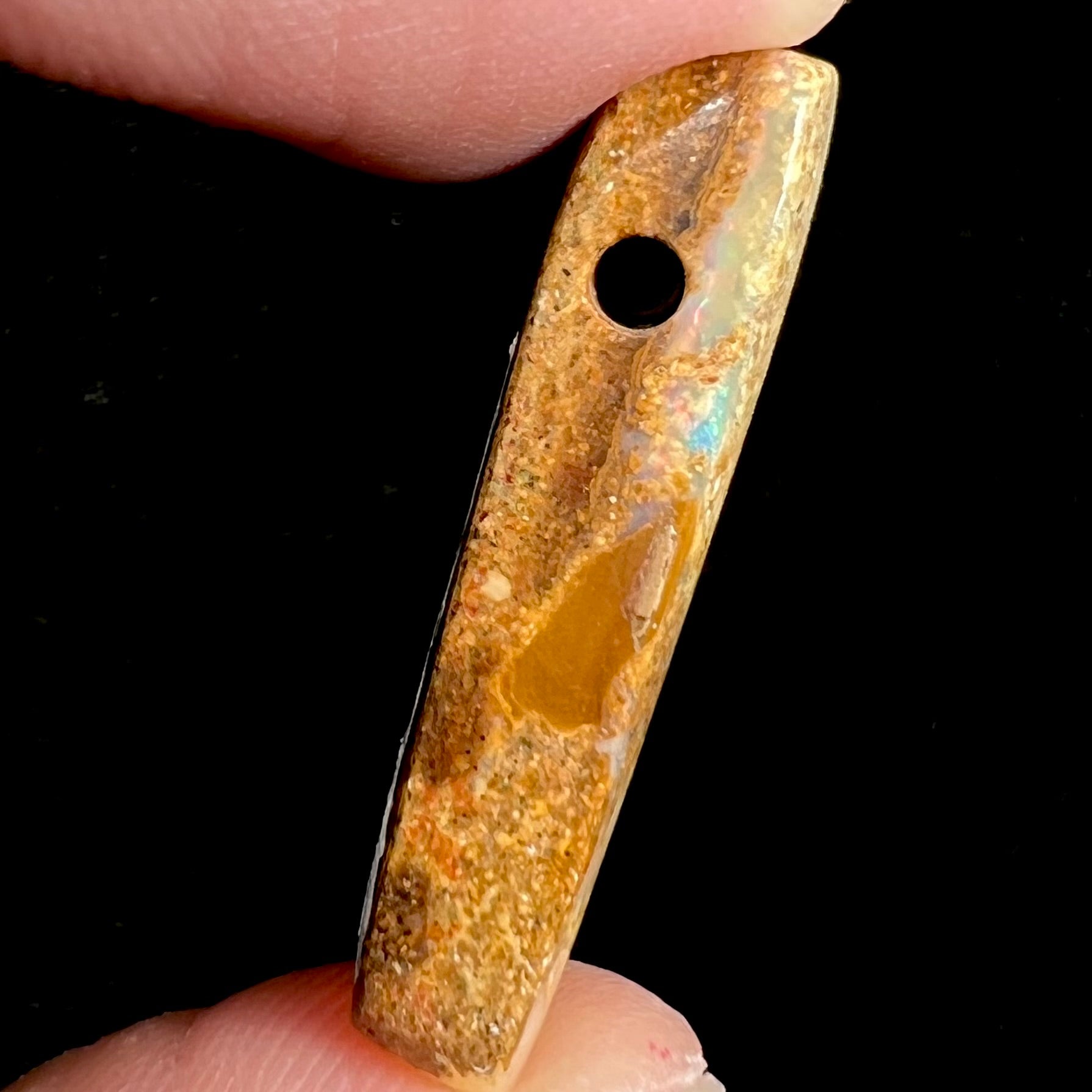 A polished, drilled pipe boulder opal bead.