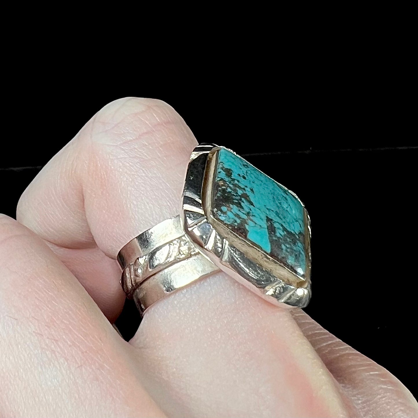 A handmade sterling silver, unisex, likely Navajo ring set with Tibetan turquoise.