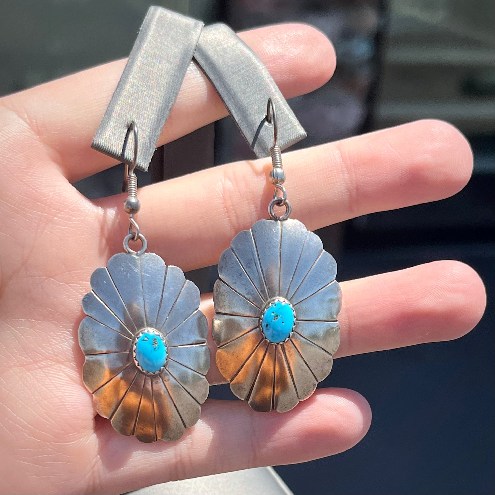 A pair of sterling silver concho turquoise dangle earrings.