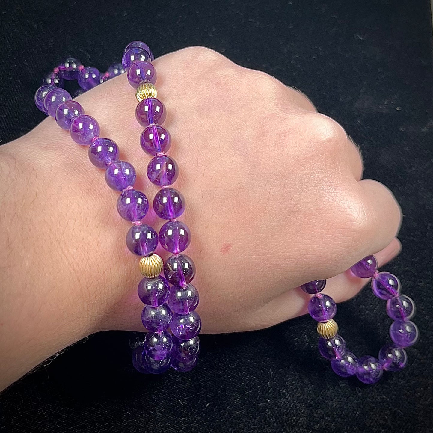 A beaded necklace made with round amethyst and 14k yellow gold beads.