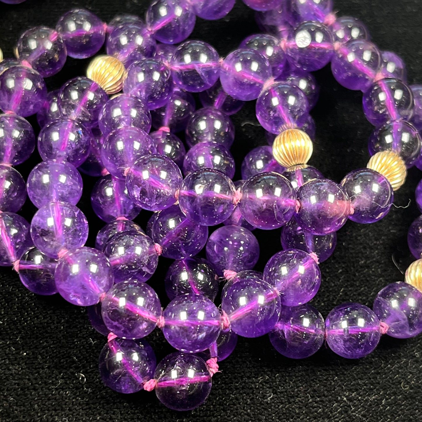 A beaded necklace made with round amethyst and 14k yellow gold beads.