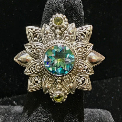 Sterling silver filigree flower design bezel set with synthetic multicolored gemstones.