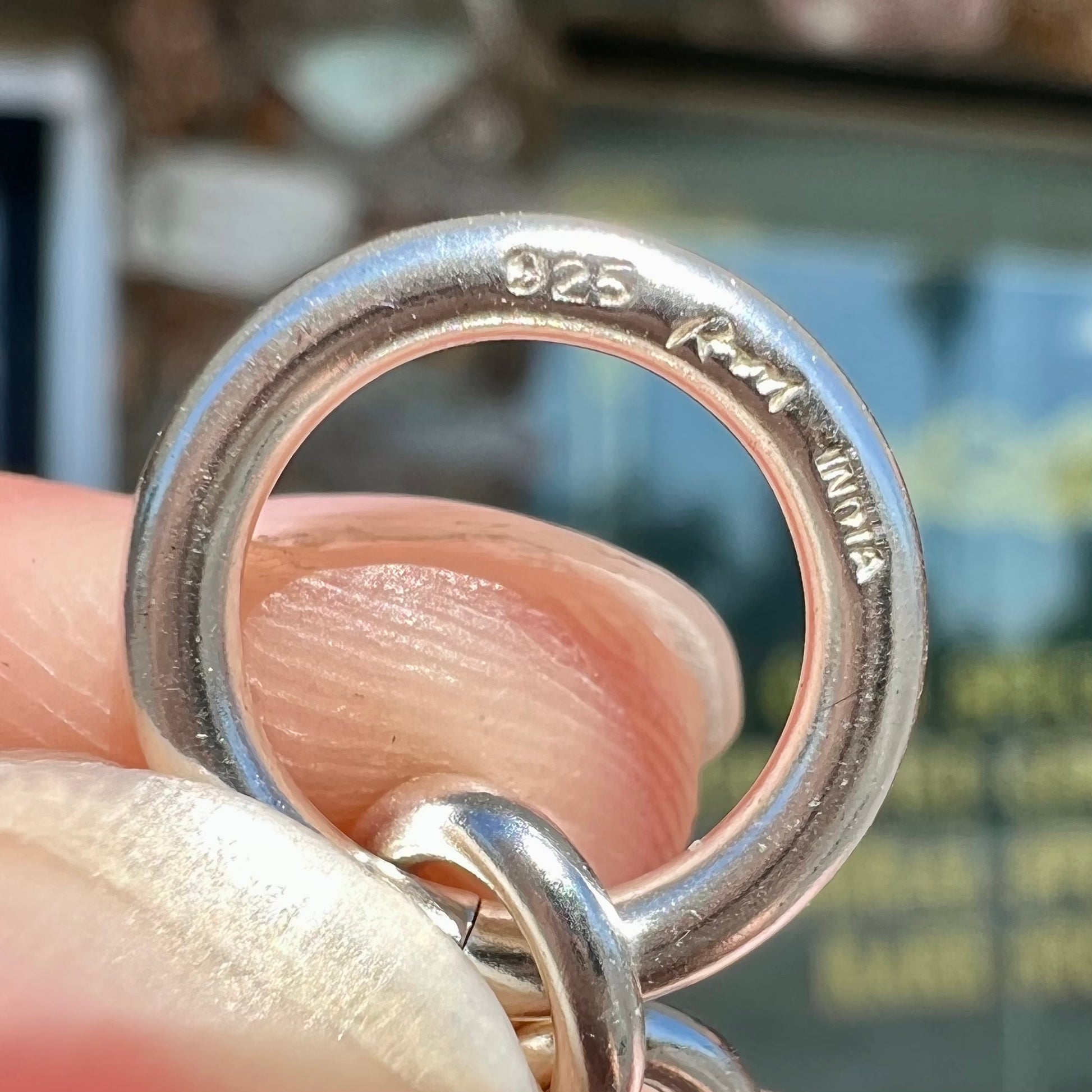 A silver toggle clasp link bracelet.  Some of the links are textured, and others are polished.  The toggle ring is stamped "India."