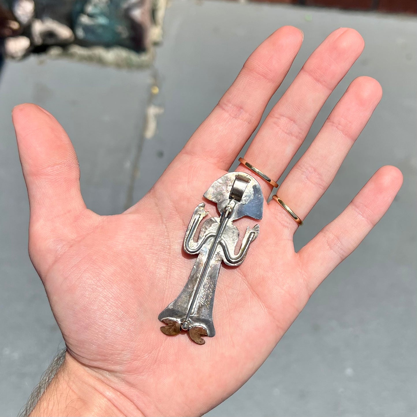 A handmade Navajo style silver pendant with copper highlights shaped like a Navajo Indian shaman.  There is a mother of pearl set as the shaman's face.