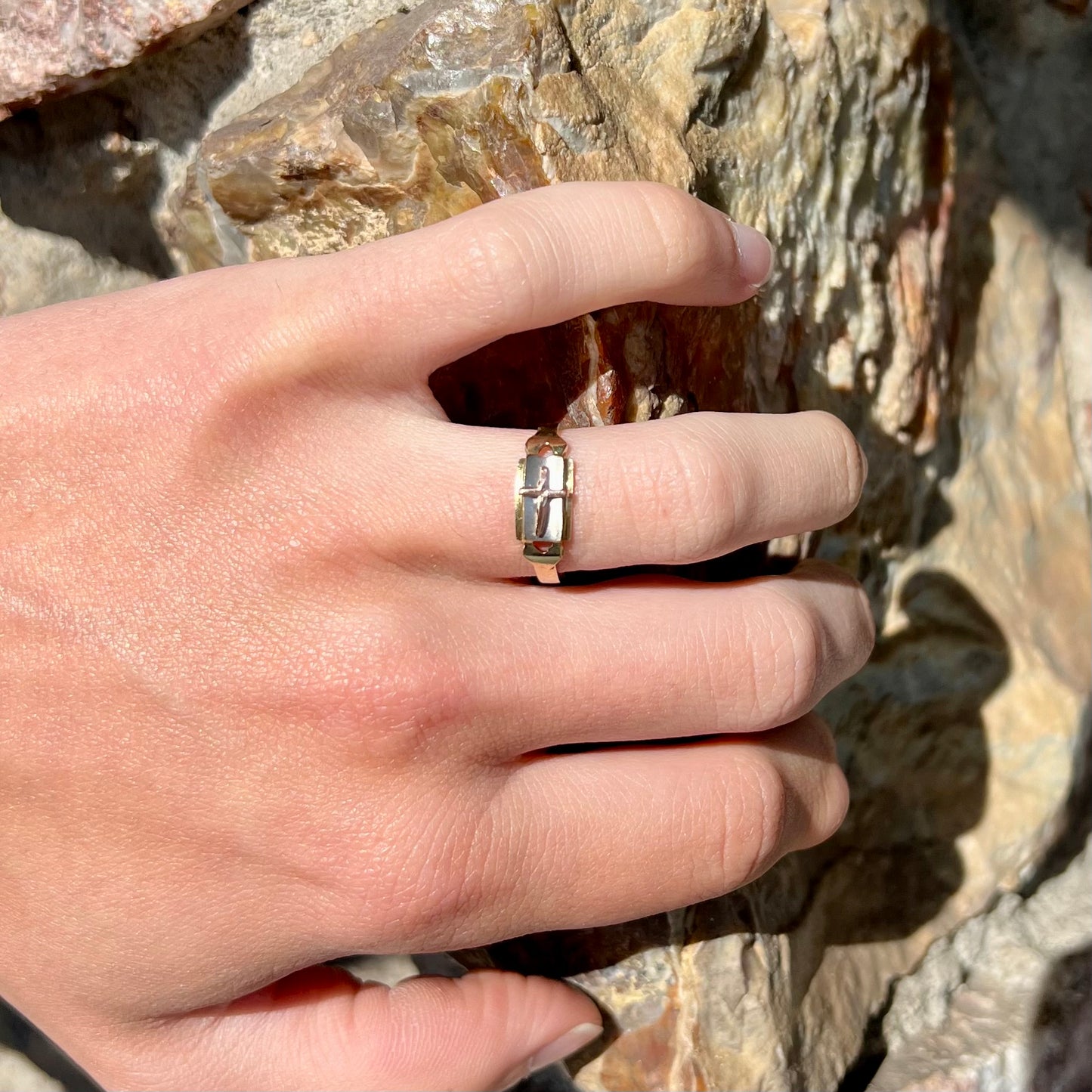 A tricolor gold cross ring handmade from rose, white, and yellow gold.