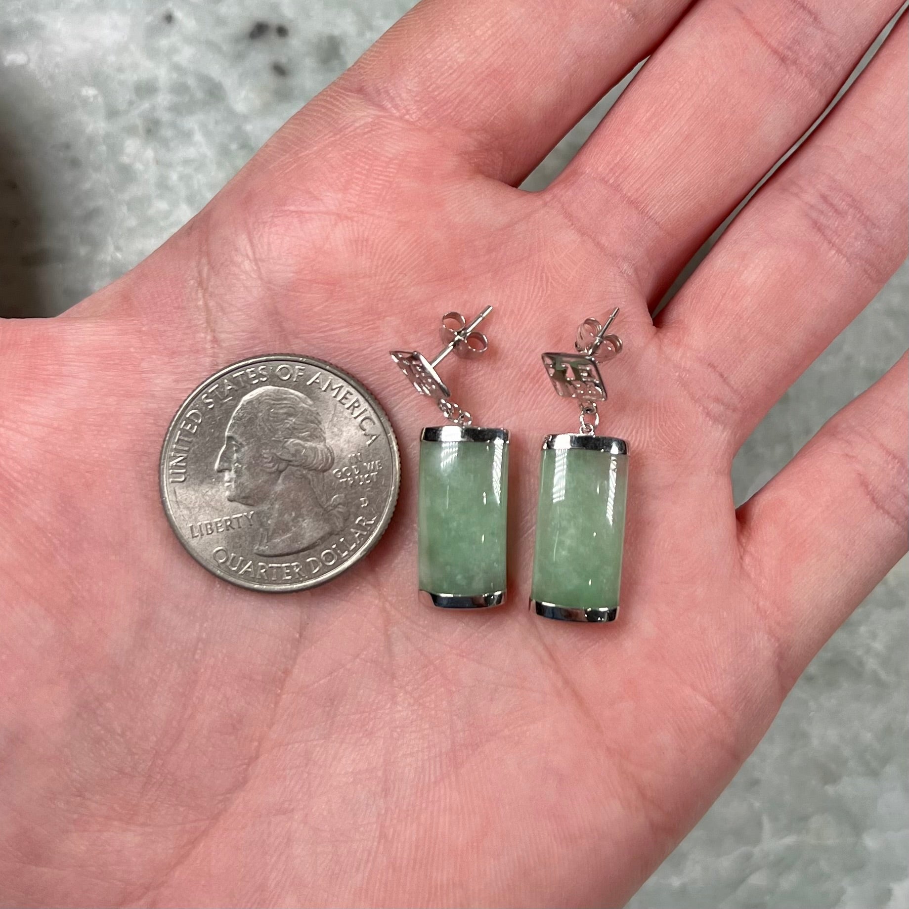 A pair of white gold jadeite dangle earrings with Chinese characters.