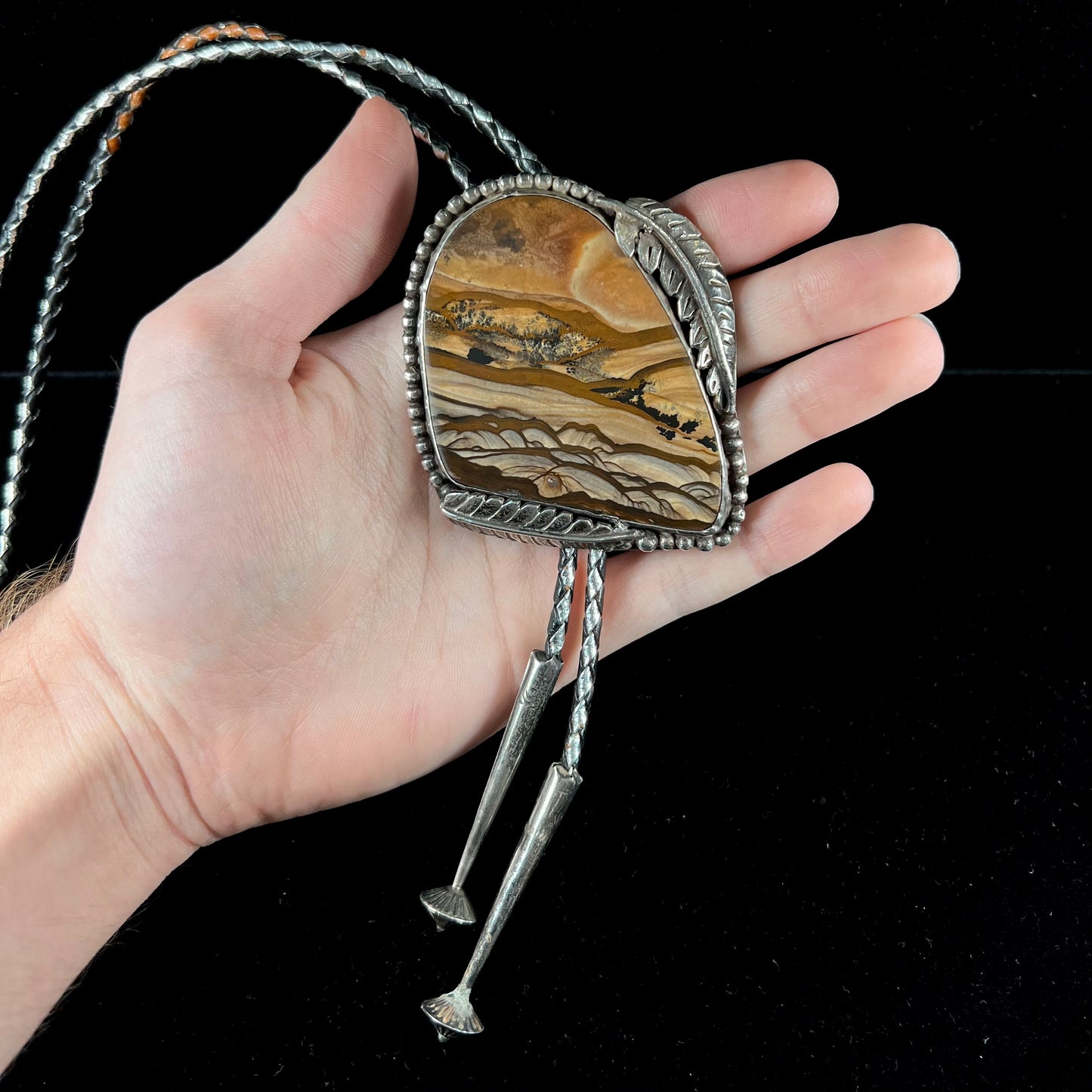 A men's sterling silver bolo tie set with a Biggs picture jasper stone.