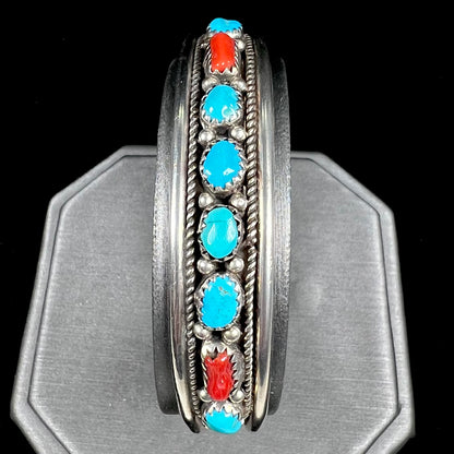 A silver ladies' turquoise and coral cuff bracelet, handmade by Navajo artist, John Delvin.