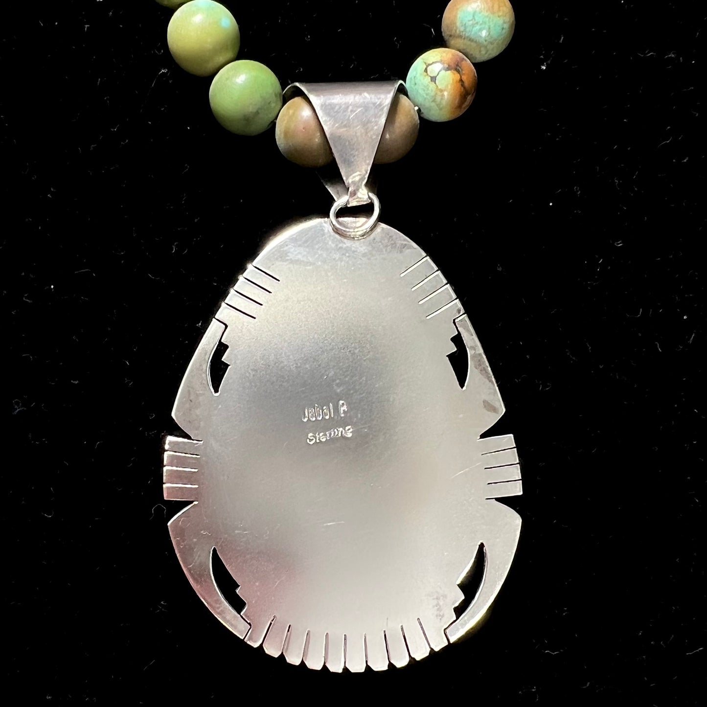 A handmade, likely Navajo silver pendant set with Kingman turquoise on a green Kingman turquoise beaded necklace.